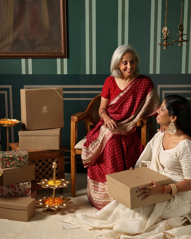 A mother receiving a Veda gift box from her daughter during Diwali